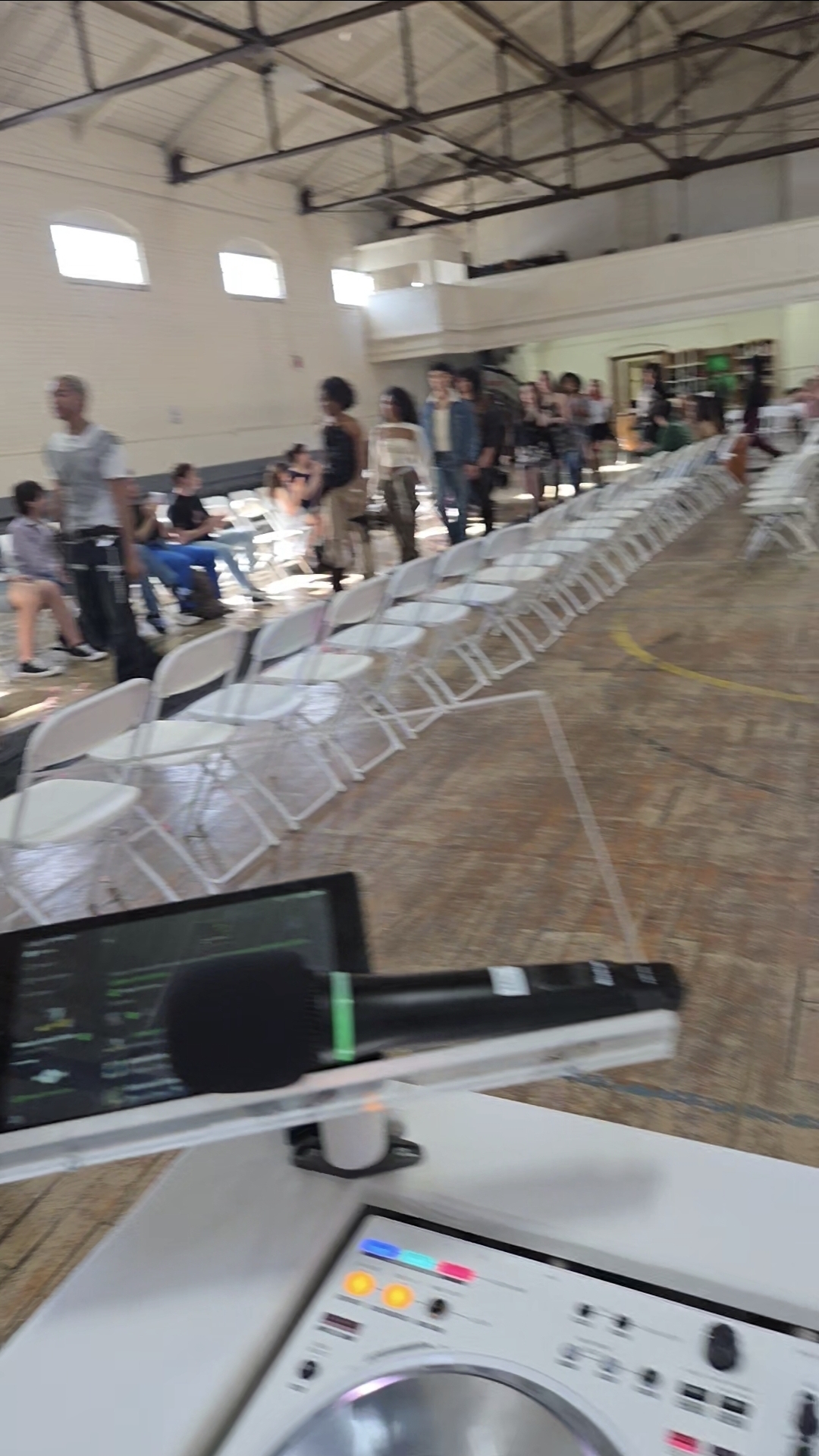 DJ view of guests gathered in a community hall with wireless microphone ready for announcements