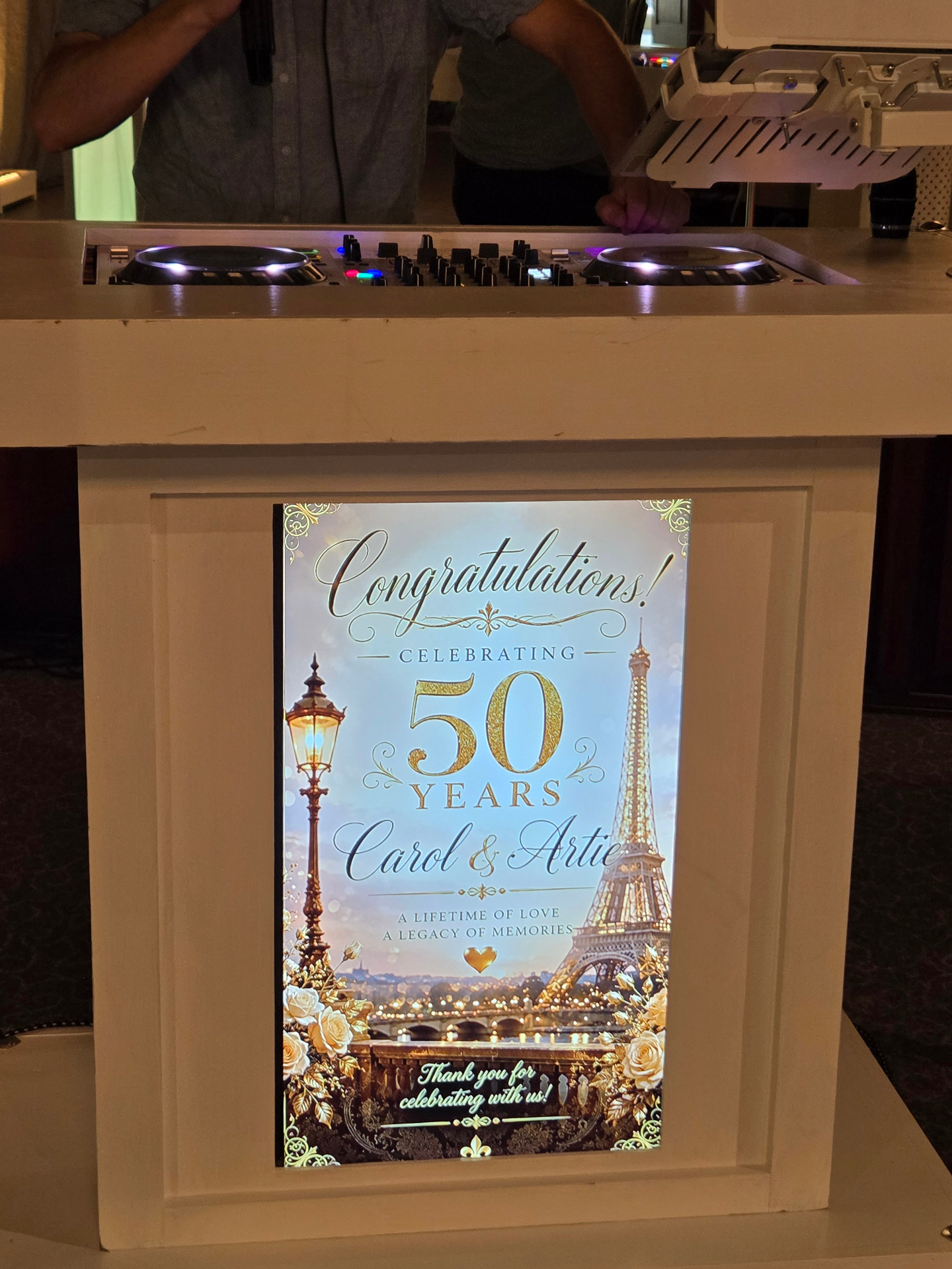 Custom DJ booth display reading 'Congratulations Celebrating 50 Years Carol and Artie'